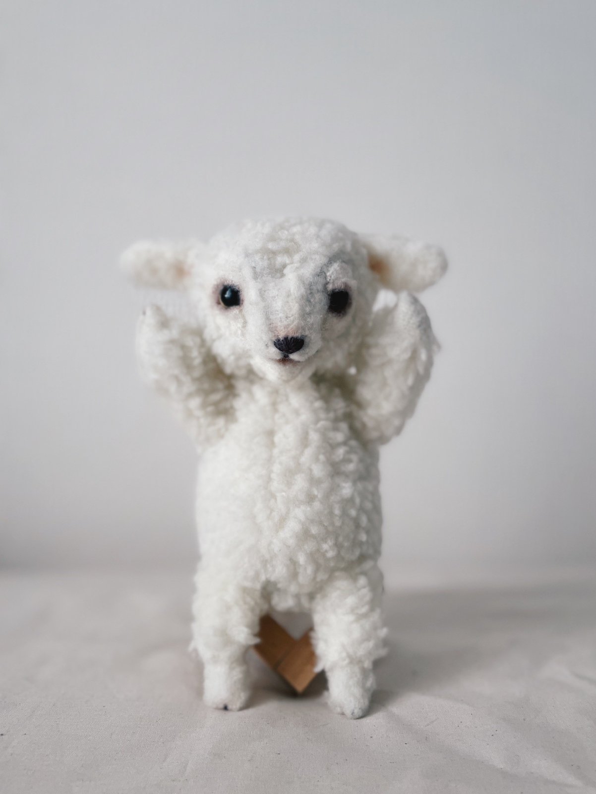 立って両手をあげるひつじのぬいぐるみ